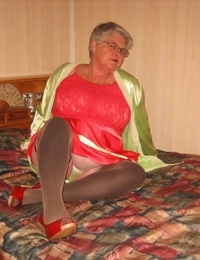Fat granny Girdle Goddess pets her pussy after stripping to hosiery on her bed