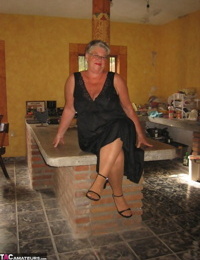 Fat oma Girdle Goddess strips to tan pantyhose on an island in the kitchen